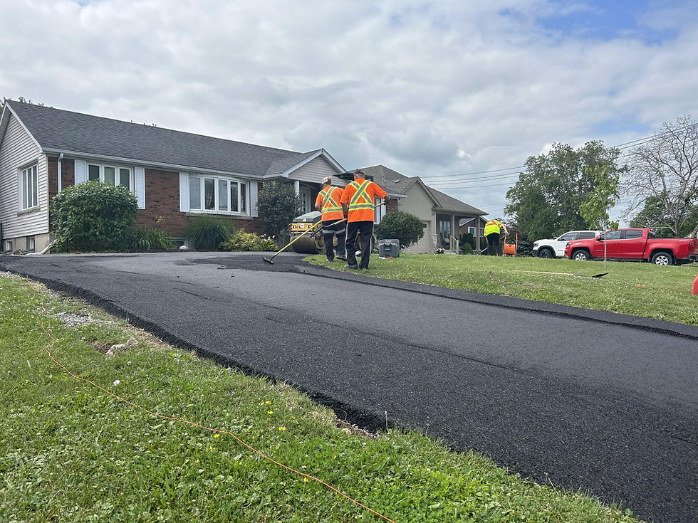 Freshly paved asphalt driveway with workers
