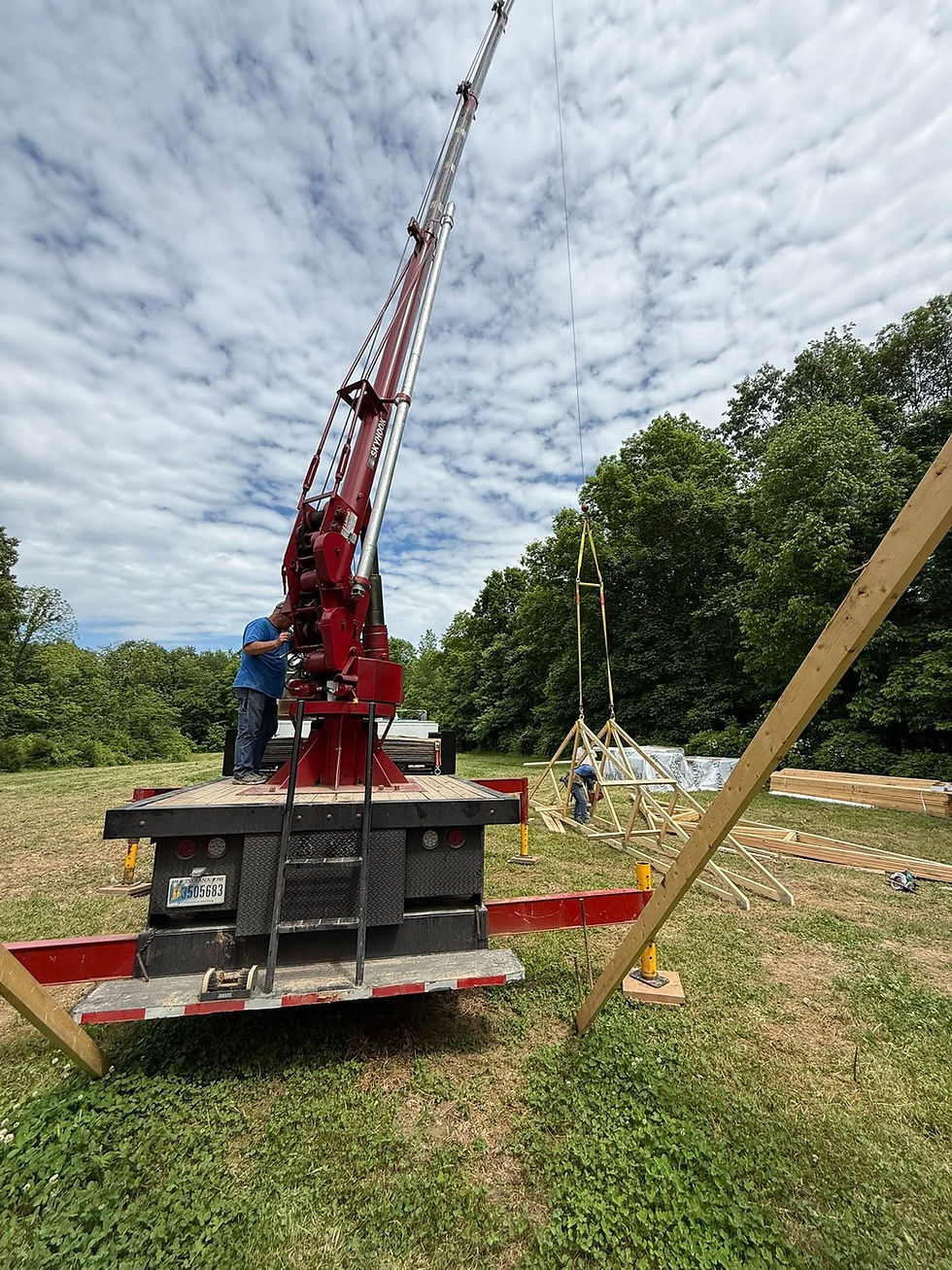 Crane preparing to raise wooden trusses on a new home build in Southern Indiana
