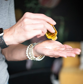 hair stylist pouring oil into hand before applying it to guests hair