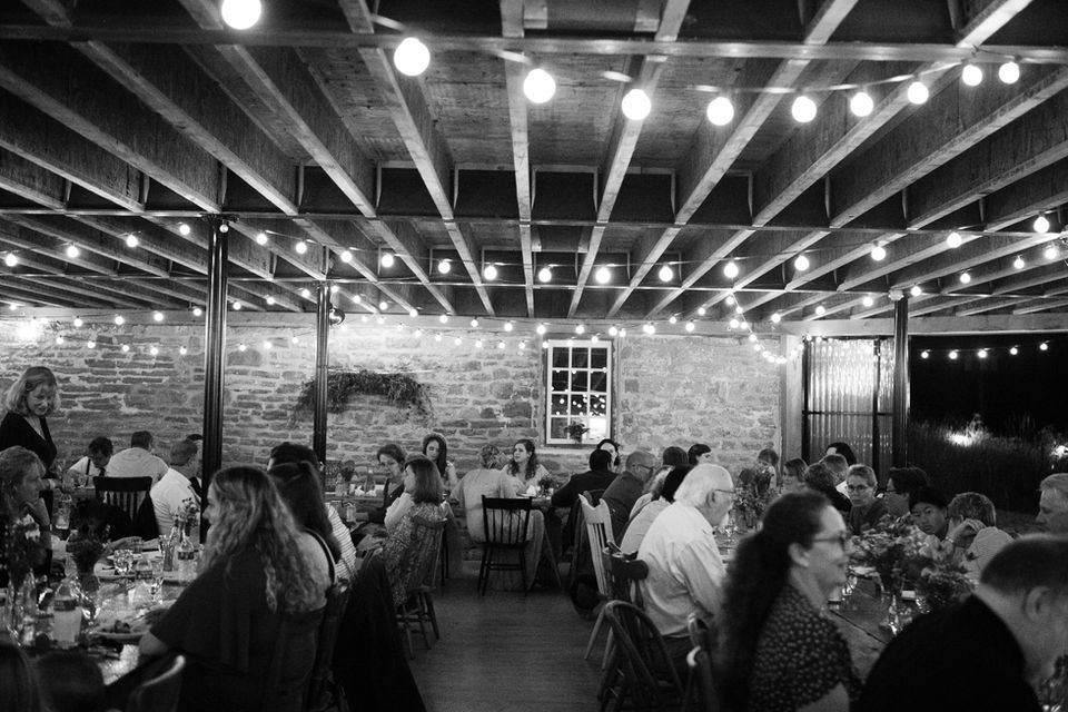 Guests dine under wooden beams and twinkle lights