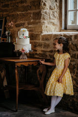 Small girl stands next to cake table