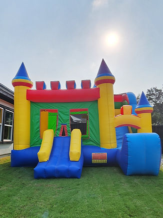 A colorful bouncy house with slide is inflated on a lawn in San Antonio, Texas.