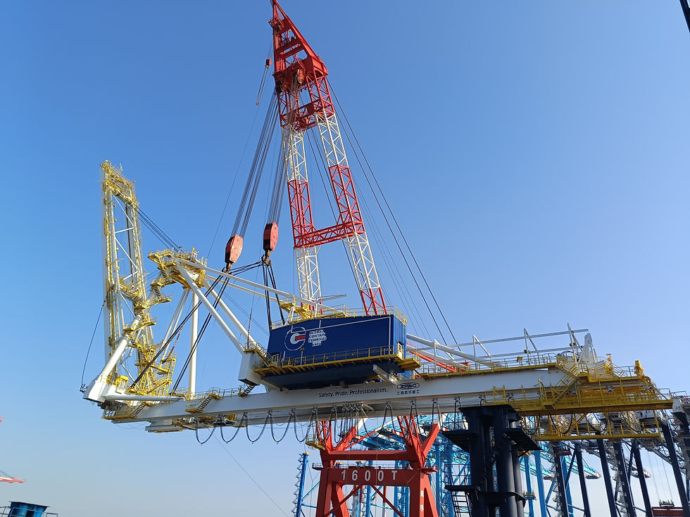 A floating crane being used to lift a container crane, which has an overhead service crane inside the blue machinery house.