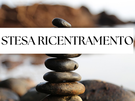 Immagine di sassi levigati impilati in equilibrio su una superficie rocciosa, con sullo sfondo un paesaggio naturale sfocato e, in primo piano, la scritta 'Stesa di Ricentramento'. La composizione rappresenta simbolicamente la ricerca di stabilità interiore e armonia tra le funzioni psichiche. L’immagine è utilizzata come introduzione visiva alla pratica tarologica di autoriflessione ispirata alla Function Block Spread di Rose Gwain, rielaborata in chiave evolutiva per aiutare a ritrovare il proprio centro attraverso le carte