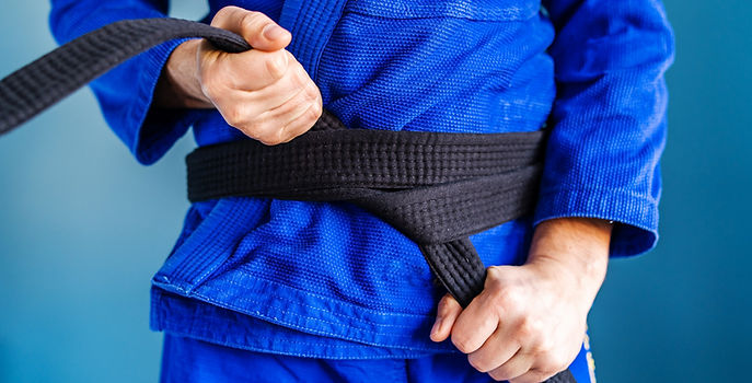 Close up on midsection of the bjj brazilian jiu jitsu or judo black belt hands holding and