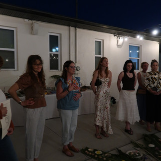 sunny stewart facilitates the closing ceremony around a large botanical mandala