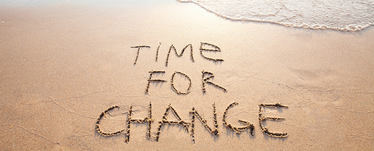 Message Time for change dessiné dans le sable