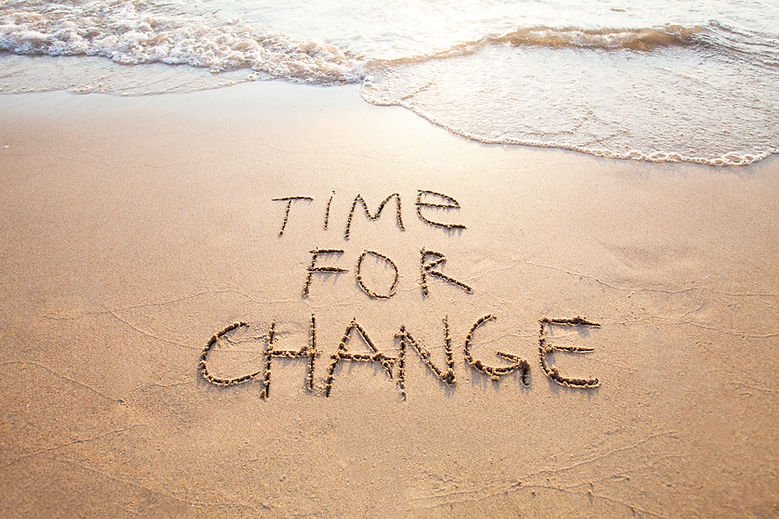 Message Time for change dessiné dans le sable