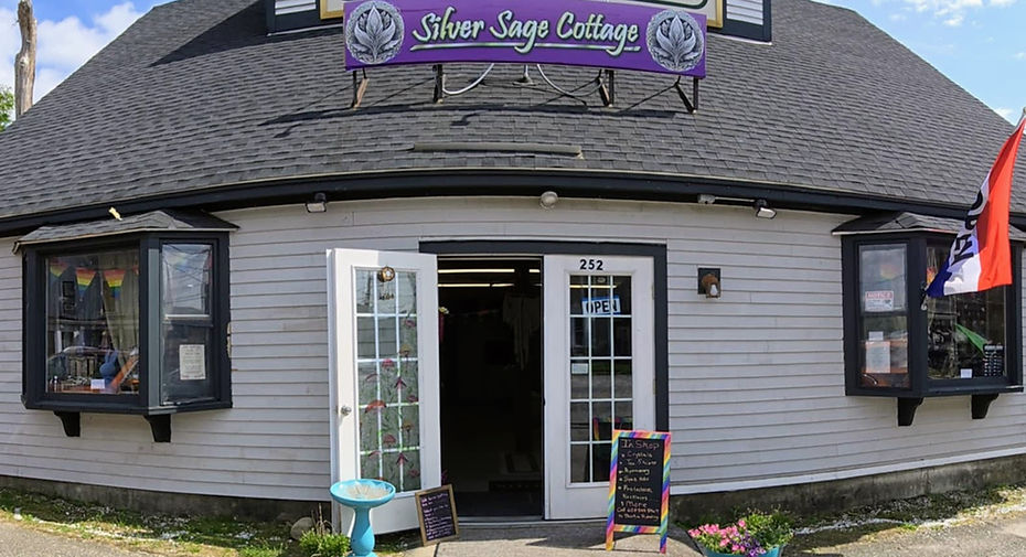 front door of silver sage cottage at 252 main street in tilton new hampshire. gray painted building with french doors open.