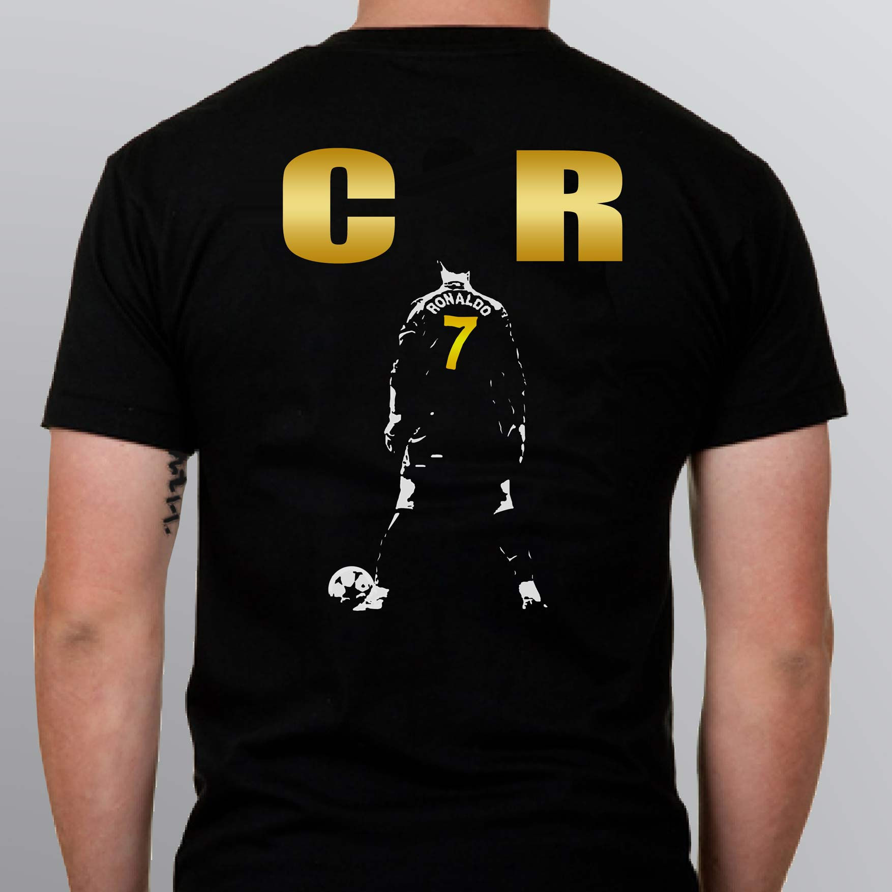 the back of a black tshirt with a white ronaldo figure and golden letters cr