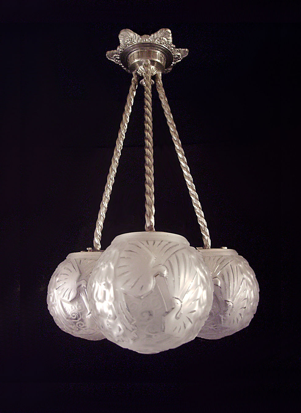 Suspension Art Déco éditée par Hubert Petitot, en bronze nickelé, équipée de trois globes en verre moulé-pressé signés Muller Frères Lunéville.