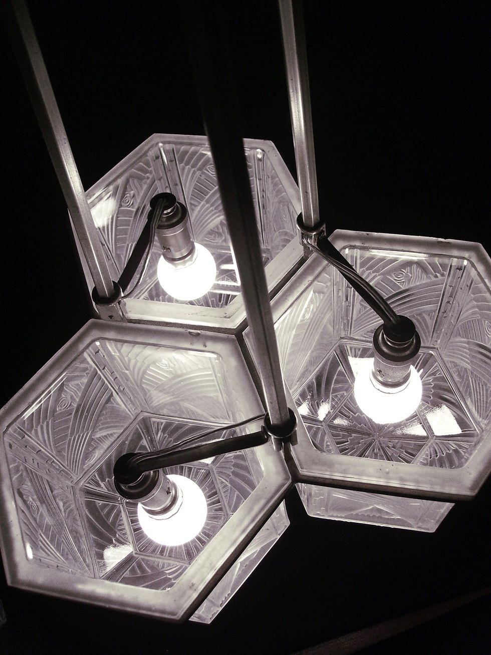 Miniature : Vue intérieure du lustre art déco Hettier et Vincent équipé de trois ampoules éclairant les globes hexagonaux en verre moulé-pressé signé.