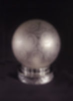Veilleuse Art déco Leunor en bronze nickelé et globe en verre gravé à décor géométrique de rosaces stylisées, présentée allumée sur fond noir.