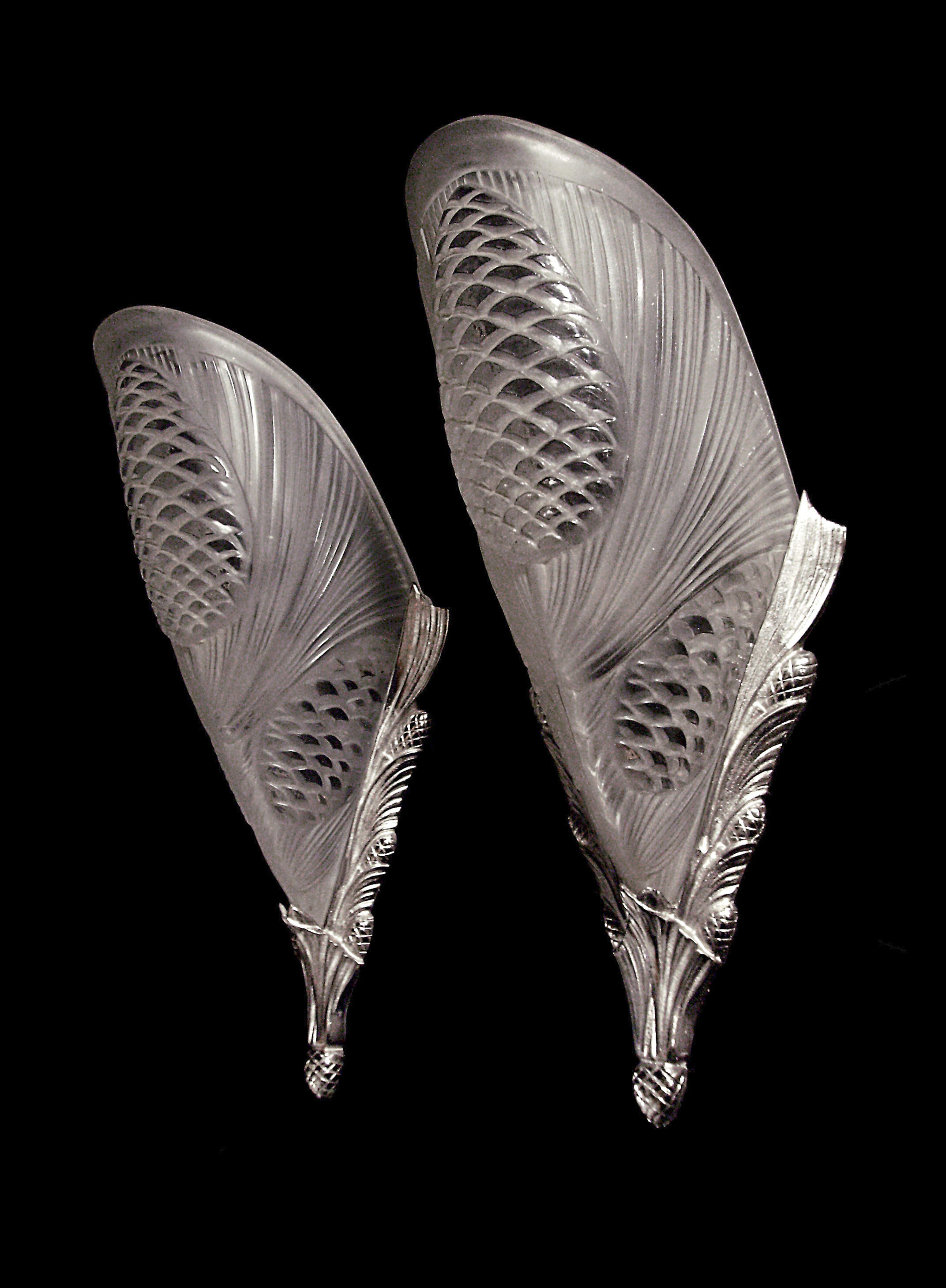 Paire d’appliques Art Déco en bronze nickelé avec sabots en verre moulé pressé à décor de pommes de pin par Degué.