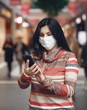 mujer joven con mascarilla médica tomando