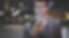A smiling man wearing eyeglasses is holding scrolling texting in his cellphone. A smiling