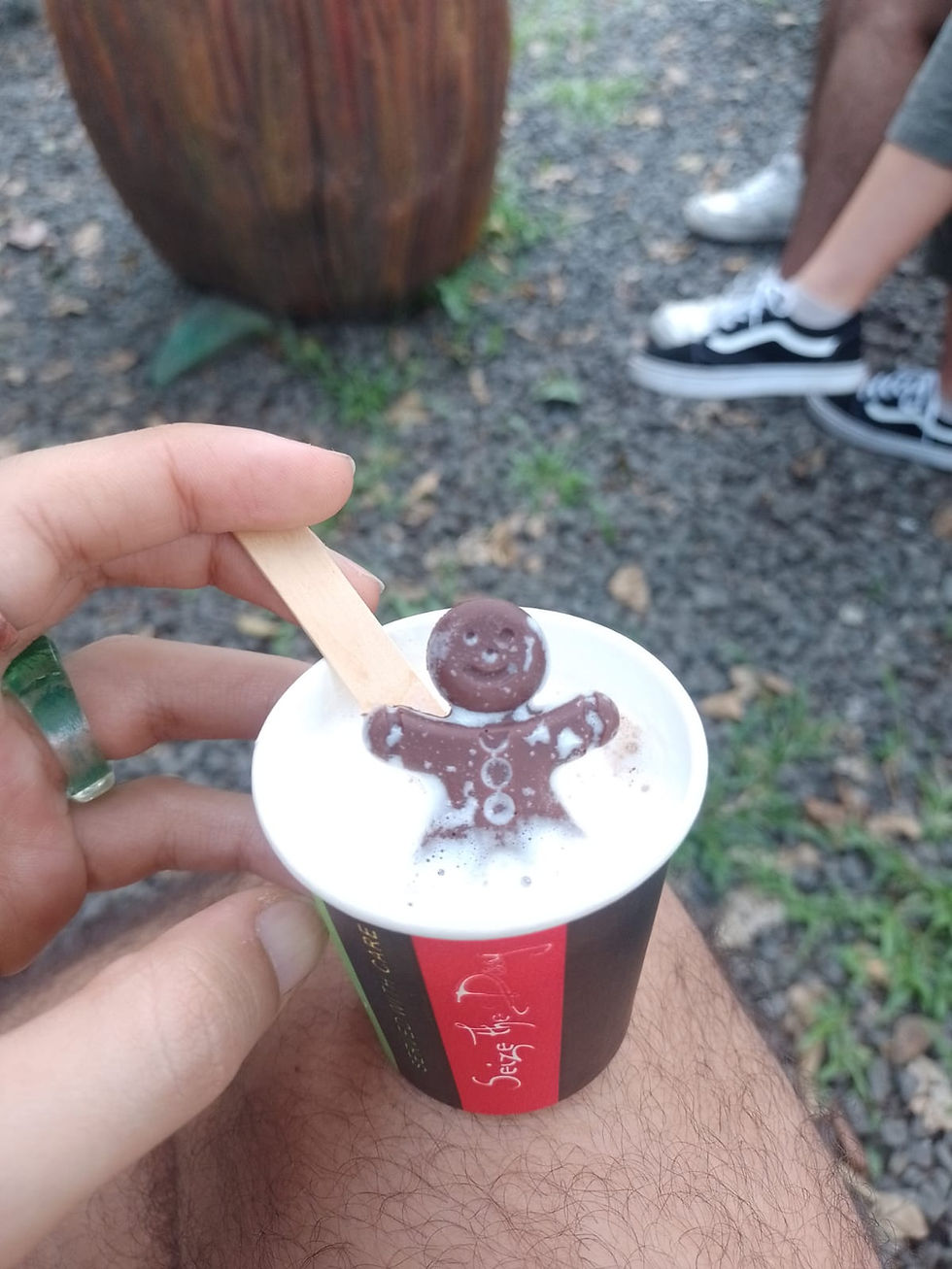 little chocolate man figure inside a milk cup on a man's leg