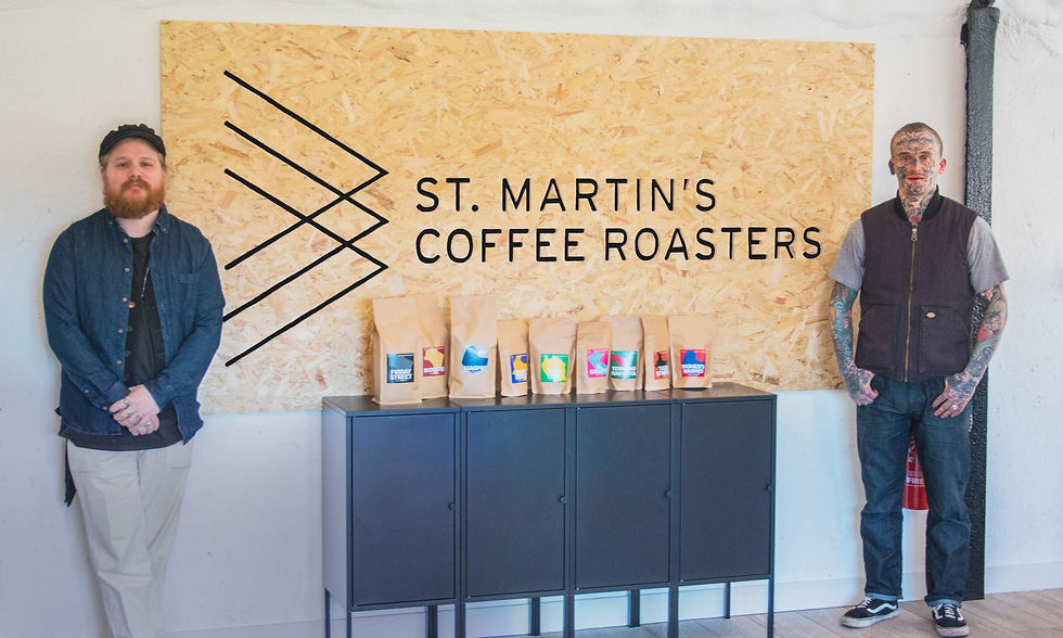 Two men stood either side of a St Martin's Coffee Roasters sign