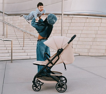 Moeder speelt met kindje in de stad naast Cybex Beezy buggy.jpg