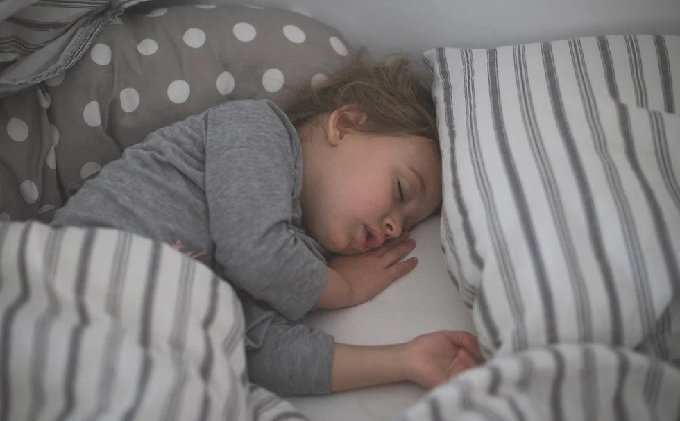 Kind schläft sicher in einem Bett.webp
