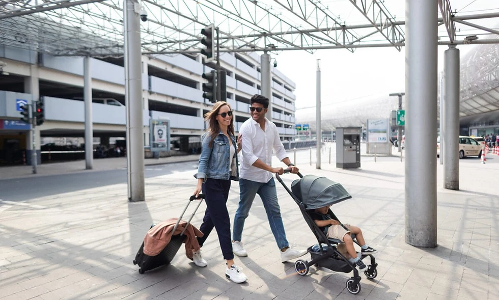 Junges Paar geht mit Kind im Joolz aer Buggy am Bahnhof spazieren.webp