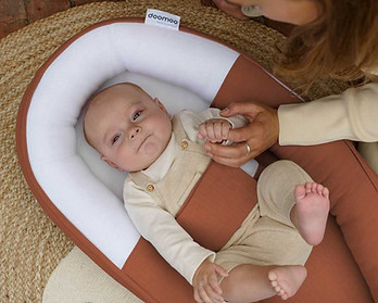 Baby ligt in Doomoo cocoon babynest terracotta.jpg