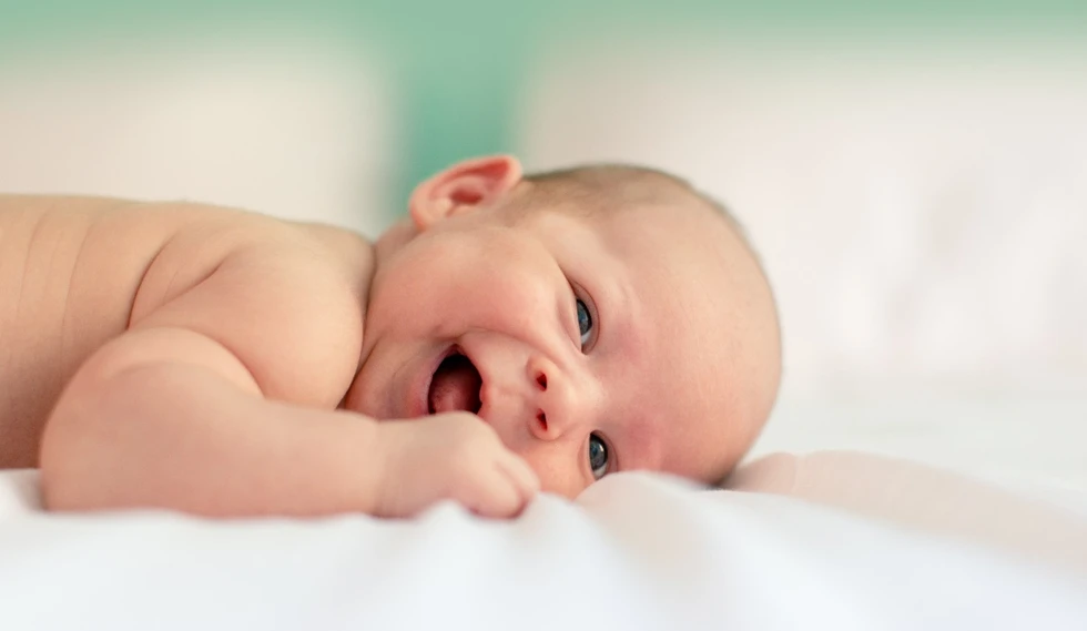 Süßes Baby liegt auf dem Bauch und lächelt