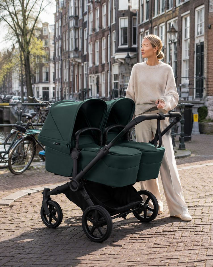 Hippe moeder naast bugaboo donkey 6 kinderwagen in amsterdam