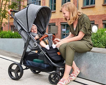 Blije moeder zit naast baby in kinderkraft grande plus goedkope kinderwagen-min.jpg