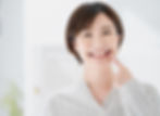 歯を指す笑顔の女性