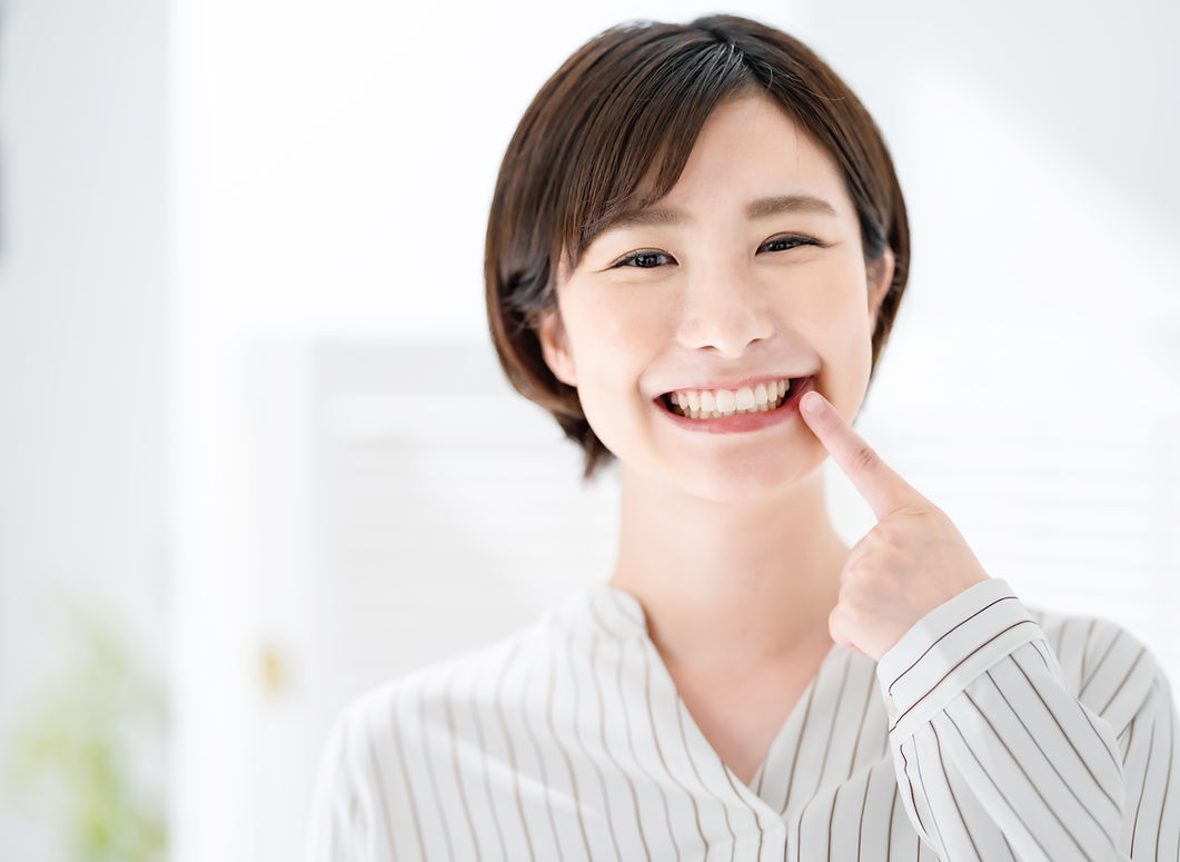 笑顔で歯を指す女性