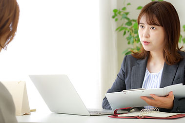話を聞くスーツ姿の女性