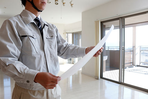 計画書を見る作業着の男性
