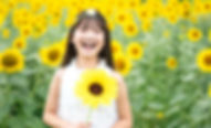ひまわり畑で笑顔の少女