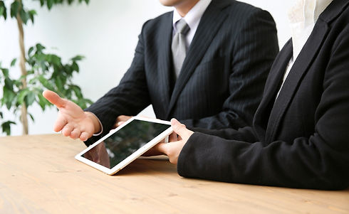 タブレットで説明するスーツの男性