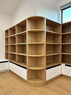 Curved light-wood corner bookshelf