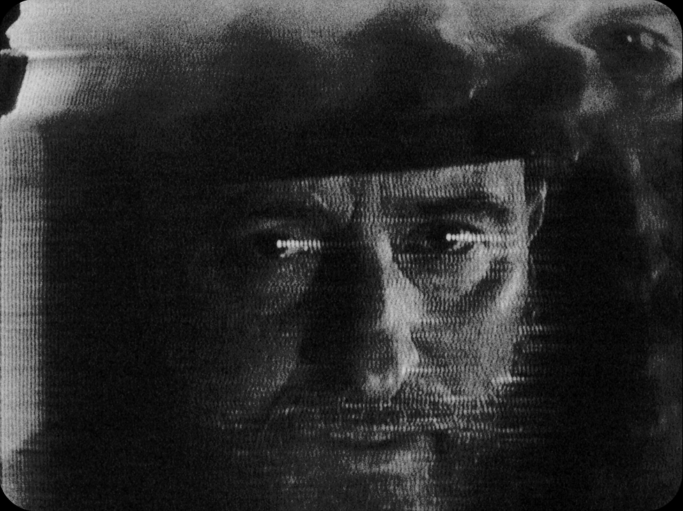 black and white portrait of singer Matthew Devereux. The image is dark, melted and destroyed: 16mm film printed onto VHS and then printed back onto super-16mm film.