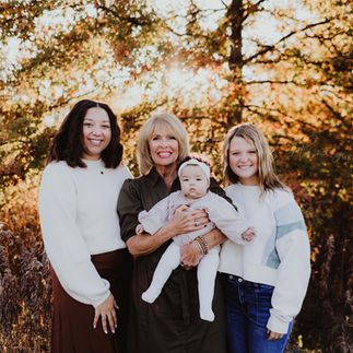 grandmother stands with all her granddaughters and great granddaughters during family photos