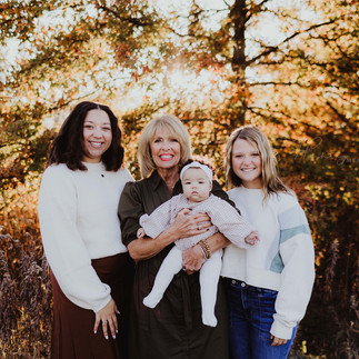 grandmother stands with all her granddaughters and great granddaughters during family photos