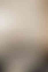 mother holds newborn in their home nursery during family photos, white nursery with white mirror and decor