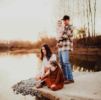 family plays at lake's edge during fall family photos, family of four with mother, father and two daughters