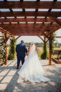 Bride and Groom under the weding arch at Blossom Barn during their summer wedding ceremony