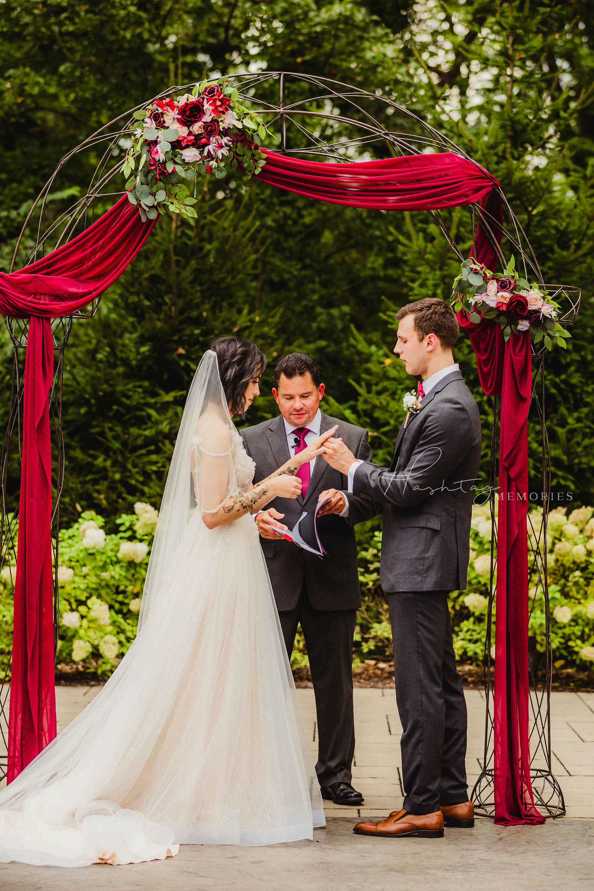 Bride and groom exchange rings during Fishers Indiana outside wedding ceremony