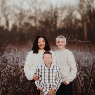 siblings stand together in frosted fall field