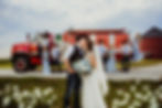 firefighter groom and bride kiss in front of fire truck with their bridal party, kissing