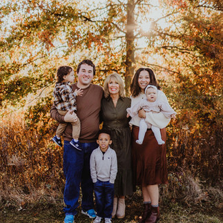 grandma stands with her granddaughter's family and great grand kids during fall family photos
