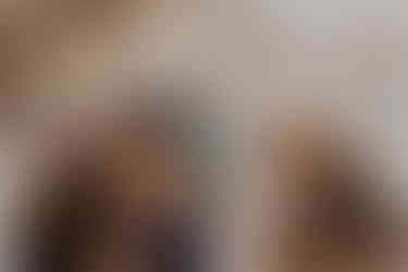 family holds thier newborn with big brother toddler looking at baby in curiosity during family photos in the client's fortville, indiana home