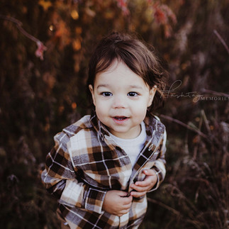 little boy smiles during fall family photos