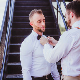 best man helps groom dress before his wedding. groom wearing fitted gym suit