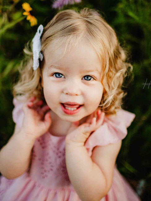 toddler girl in pink dress smiles and laughs during family photos in cicero indiana